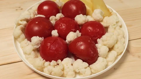 Pickled vegetables with tomatoes and cauliflower rotating on plate Stock Footage 339367074