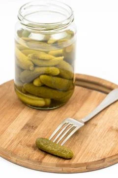 Pickles in the jar and on fork isolated over white background Stock Photos