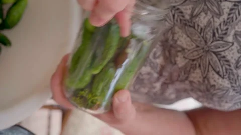 Pickling cucumbers. the process of placing cucumbers in jars. 스톡 동영상 245984512