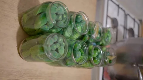 Pickling cucumbers. the process of placing cucumbers in jars. 스톡 동영상 245984614