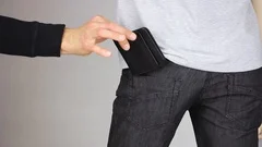 Pickpocket crime. thief hand steal wallet from jeans pocket