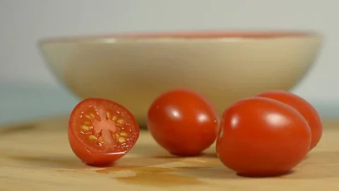Picks up a cut piece of cherry tomato from the table Stock Footage 128917769