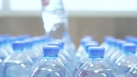Picks out a plastic, clear bottle of water from a row in the supermarket Stock Footage 221497919