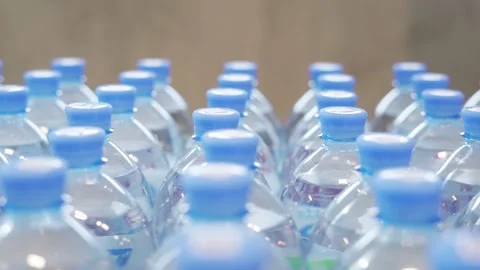 Picks out a plastic, clear bottle of water from a row in the supermarket Stock Footage 221497937