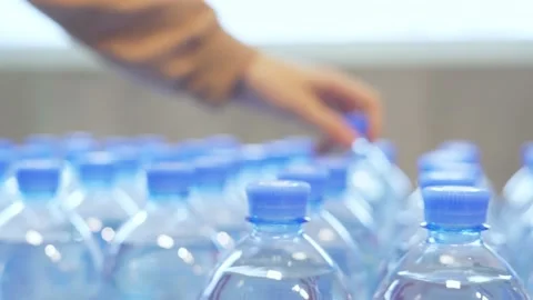 Picks out a plastic, clear bottle of water from a row in the supermarket Stock Footage 221497970