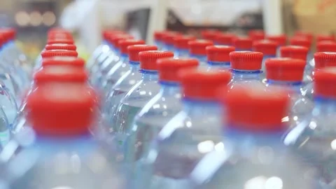 Picks out a plastic, clear bottle of water from a row in the supermarket Stock Footage 221498013