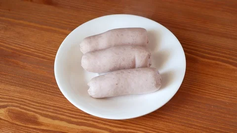 Picks up a sausage from a plate. Stock Footage 70400172