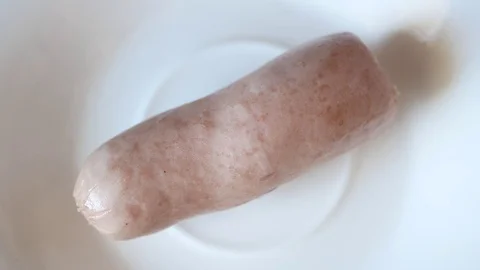 Picks up a sausage from a plate. Video stock 70400299