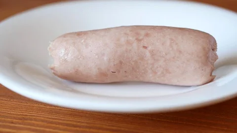 Picks up a sausage from a plate. Stock Footage 70400319