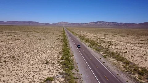 Pickup driving down long straight road in desert Stock-Footage 92829841