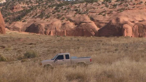 Pickup truck at base of Wingate Cliffs at Red Rock Park, New Mexico USA Stock Footage 103551356
