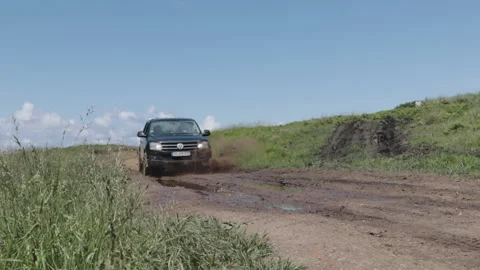 Pickup truck driving through puddle splashing mud in slow motion Stock Footage 138762824