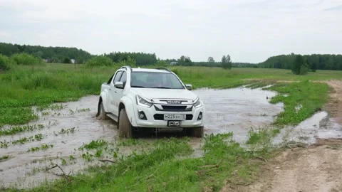 Pickup truck turning in a mud puddle with slipping wheels Stock Footage 157054476