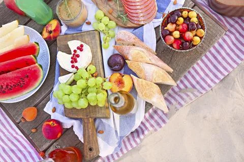 Picnic on the beach at sunset in the style of boho. Food and drink, relax, Foto stock