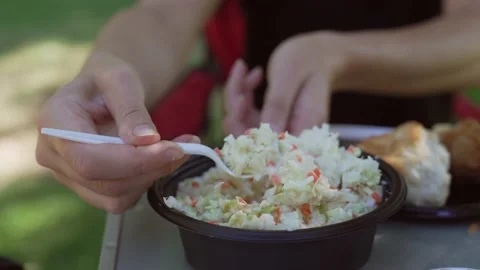 Picnic close up hand takes serving of coleslaw Stock Footage 156874308