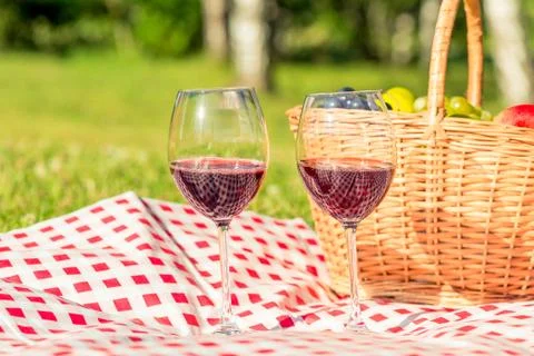 Picnic on the lawn objects - two glasses of wine and a basket of fruit on tab Stock Photos