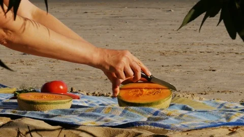 Picnic on a river beach - cutting melon - 4k Stock Footage 82294605