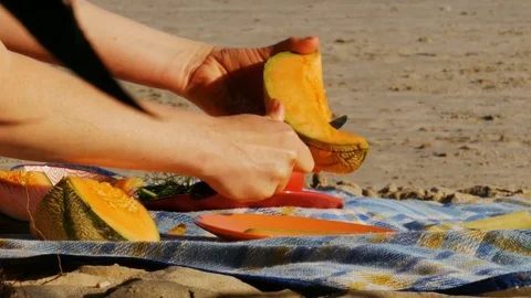 Picnic on a river beach - cutting melon - 4k Stock Footage 82297449
