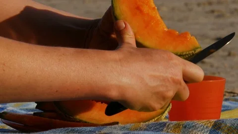 Picnic on a river beach - cutting melon - 4k Stock Footage 82302845