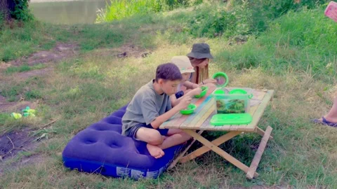 Picnic setup with small table and air mattress near green trees Stock Footage 340464155