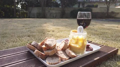 Picnic in the sun with wine, bread and sausage waiting in the sun, HD Stock Footage 158627488
