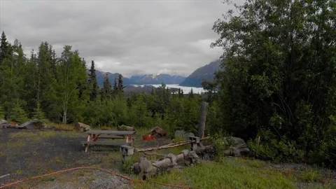Picnic table overlooking glacier mountains in forest cloudy day Alaska Stockbeeldmateriaal 105122407