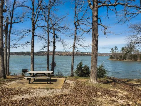 Picnic table at river park in wooded area Stock Photos