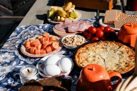 Picnic table set: nuts, pie, eggs, tomatoes, carrots. Harvest table outside Stock Photos