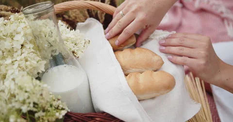Picnic wicker basket with bread, milk and wildflowers Stock Footage 142246015