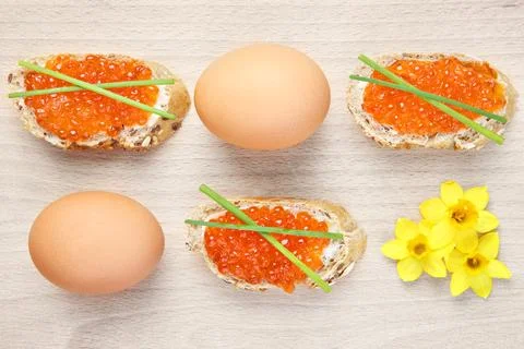 A picture of an Easter composition of eggs caviar and flowers over natural .. Stock Photos