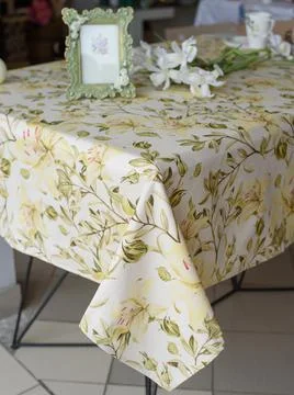 Picture frame and flowers on a table with tablecloth with lily print Stock Photos