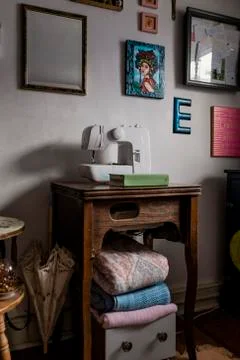 Picture frames hanging on wall over sewing machine at home Stock Photos