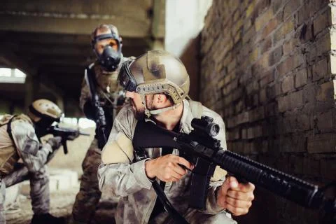 A picture of guy looking for an aim. He is loooking through loop gun. He is Stock-Fotos