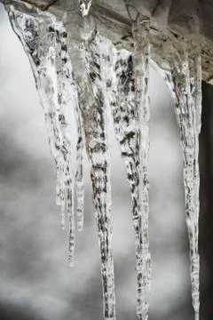 A picture of icicles hanging down from a structure outdoor. Stock Photos