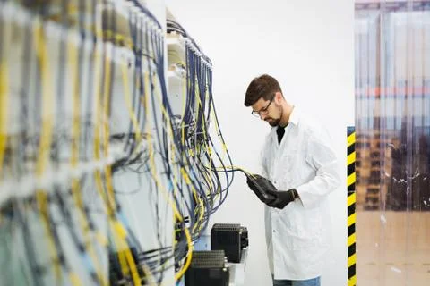 Picture of network technician testing modems in factory Stock Photos