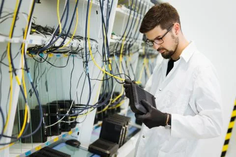 Picture of network technician testing modems in factory Stock Photos