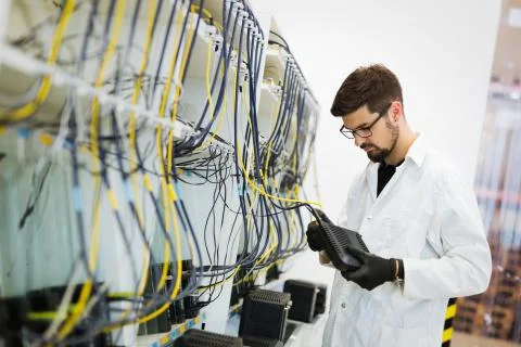 Picture of network technician testing modems in factory Stock Photos