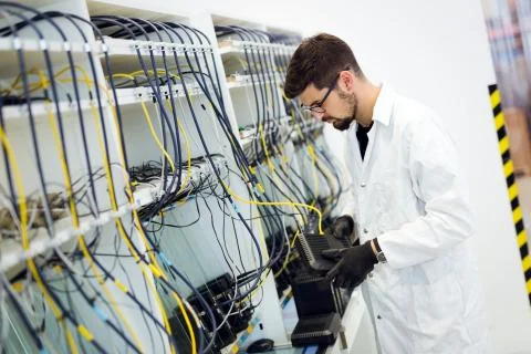 Picture of network technician testing modems in factory Stock Photos