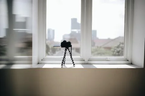 Picture of a still camera by the window doing a time lapse of a sky Stockfoto's