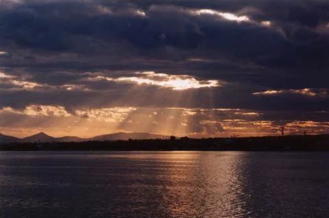 Picture of sun rays passing through storm clouds Stock Photos