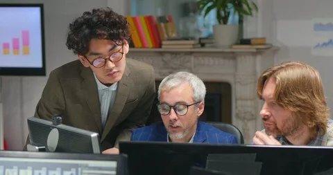 Picture of three male programmers working on computers Video stock 99230730