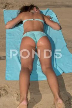 Picture of a young girl laying on a towel Stock Photos