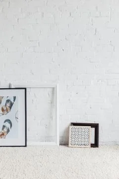 Pictures in frames leaning on white brick wall, mockup concept Stock Photos