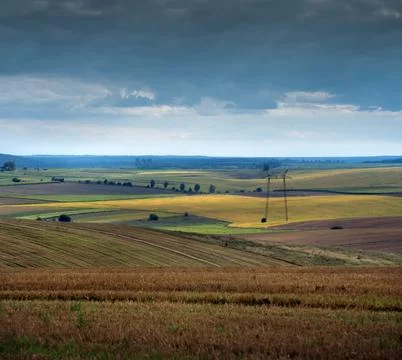 Picturesque agricultural fields under a cloudy sky Stock Photos