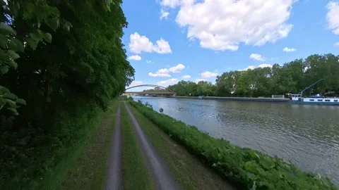 A picturesque and serene river path adorned with a modern bridge surrounded by Stock Footage 305571221