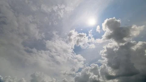 A picturesque dynamic sky adorned with fluffy clouds and radiant sunlight peekin Stockfoto's