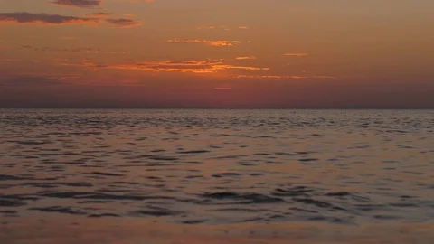 Picturesque endless ocean waves reflect orange sunset clouds Stock Footage 124023850