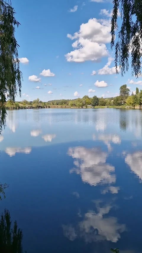 Picturesque lake with mirror reflection of clouds on a sunny day Stock Footage 346072755