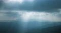 Picturesque mountain hill on background of cloud stream with foggy sunlight beam 4k or 4k+ Resolution