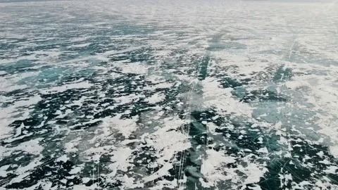 A picturesque pattern of lake ice formed by cracks, islands of snow and bubbles Stock Footage 220004335